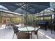 Outdoor patio with dining table, umbrella, grill and comfortable seating in a screened enclosure at 610 Poinsettia Rd, Nokomis, FL 34275