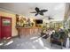 Covered patio with a rustic bar, ceiling fans, and comfortable seating, perfect for entertaining at 610 Poinsettia Rd, Nokomis, FL 34275