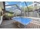 Outdoor patio with a ping pong table, seating and surrounding screened enclosure at 610 Poinsettia Rd, Nokomis, FL 34275