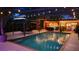 Inviting pool area with ambient lighting, outdoor seating, and a poolside bar, perfect for evening gatherings at 610 Poinsettia Rd, Nokomis, FL 34275