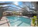 Enclosed pool area with crystal clear water, outdoor dining space, and lush landscaping at 610 Poinsettia Rd, Nokomis, FL 34275