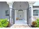 Inviting covered entryway with double doors, brick walkway, sidelight, and potted flowers at 6316 Foxbrook Trl, Parrish, FL 34219