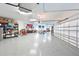 Expansive garage with epoxy flooring, organized shelving, and multiple overhead doors at 6316 Foxbrook Trl, Parrish, FL 34219
