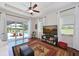 Living room with wood floors, ceiling fan, sliding glass doors with a view of the pool at 6316 Foxbrook Trl, Parrish, FL 34219