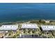 Aerial view of waterfront condos, manicured lawns, and beach at 6400 Flotilla Dr # 87, Holmes Beach, FL 34217