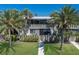 Attractive two-story condo featuring vibrant green grass, mature palm trees and well-kept landscaping at 6400 Flotilla Dr # 87, Holmes Beach, FL 34217