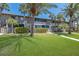 Beautiful two-story condo building with palm trees and a well-manicured lawn in a tropical setting at 6400 Flotilla Dr # 87, Holmes Beach, FL 34217