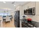 Stylish kitchen with stainless steel appliances, mosaic backsplash, and an open layout to the dining and living area at 6400 Flotilla Dr # 87, Holmes Beach, FL 34217