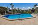 A sparkling outdoor community pool surrounded by lush greenery and lounge chairs offers a relaxing retreat at 6400 Flotilla Dr # 87, Holmes Beach, FL 34217