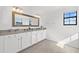 Elegant bathroom featuring double sinks, granite countertops, a large mirror, and vanity lighting at 6535 Clairborne Ln, Bradenton, FL 34211