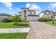 Beautiful two-story home with a paver driveway, well-manicured lawn, and lush landscaping at 6535 Clairborne Ln, Bradenton, FL 34211