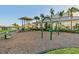Community playground with slides, swings, and climbing structures surrounded by lush landscaping and a vibrant green lawn at 6535 Clairborne Ln, Bradenton, FL 34211