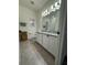 Bright bathroom with double sink, granite countertops, white cabinets, and coordinated accessories at 7322 34Th E Ct, Sarasota, FL 34243