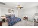 Bedroom with neutral carpet, ceiling fan, and a patterned quilt on the bed at 7322 34Th E Ct, Sarasota, FL 34243