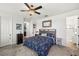 Bedroom with neutral carpet, ceiling fan, and a patterned quilt on the bed with ensuite bathroom at 7322 34Th E Ct, Sarasota, FL 34243