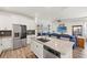 Open concept kitchen with stainless steel appliances and an eat-in island flowing into the living area at 7322 34Th E Ct, Sarasota, FL 34243