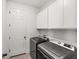 Well-lit laundry room with new washer and dryer, storage cabinets, and a door leading to other areas at 7322 34Th E Ct, Sarasota, FL 34243