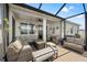 The cozy screened patio is equipped with comfortable seating, string lights and a ceiling fan at 7322 34Th E Ct, Sarasota, FL 34243
