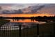 Scenic view of a vivid sunset over a pond, captured from behind a black metal fence at 7322 34Th E Ct, Sarasota, FL 34243