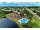 Aerial view showcasing community tennis courts, pool, and serene lake, surrounded by lush greenery at 7814 48Th E Ave, Bradenton, FL 34203