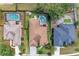 Drone shot highlighting backyard pools, sheds, and neighboring houses in a neatly arranged community at 7814 48Th E Ave, Bradenton, FL 34203