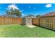 A simple storage shed stands in a well-maintained backyard with a wooden fence at 7814 48Th E Ave, Bradenton, FL 34203