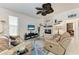 Comfortable living room with a stone fireplace, modern ceiling fan, and neutral color palette at 7814 48Th E Ave, Bradenton, FL 34203