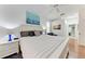 Bright main bedroom with a white, nautical theme, wood floors, en suite bathroom and large windows at 7814 48Th E Ave, Bradenton, FL 34203