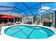 Sparkling pool with screened-in enclosure, surrounded by outdoor seating and lush landscaping at 7814 48Th E Ave, Bradenton, FL 34203