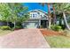 Charming two-story home with brick driveway, lush landscaping, and inviting curb appeal at 8243 Nandina Dr, Sarasota, FL 34240