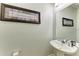 Tastefully decorated half bathroom with a pedestal sink, stylish mirror, and wall art at 8243 Nandina Dr, Sarasota, FL 34240