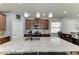 Open kitchen with granite island, pendant lighting, and views into the adjacent dining area at 8243 Nandina Dr, Sarasota, FL 34240