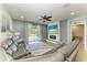 Open-concept living room with a grey leather sectional, fireplace, and access to the patio at 8243 Nandina Dr, Sarasota, FL 34240