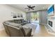 Bright living room featuring a leather sectional, fireplace, and sliding glass doors to the backyard at 8243 Nandina Dr, Sarasota, FL 34240