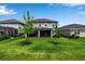Expansive lawn with young trees featuring a large backyard and screened-in lanai, ideal for outdoor activities at 8346 Abalone Loop, Parrish, FL 34219