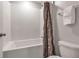 Bathroom with a shower-tub combo, white subway tile, and neutral-toned shower curtain at 8346 Abalone Loop, Parrish, FL 34219