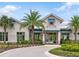 Community building features large windows, an American flag, tropical foliage, and a brick-paved roundabout at 8346 Abalone Loop, Parrish, FL 34219