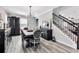 Open dining room featuring wood floors, decorative lighting, and a wooden table with upholstered chairs at 8346 Abalone Loop, Parrish, FL 34219