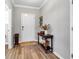 Warm foyer with wood-look flooring, decorative table, and natural light at 8346 Abalone Loop, Parrish, FL 34219