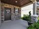 Inviting front porch with stone accents, decorative wreath, and lush greenery at 8346 Abalone Loop, Parrish, FL 34219