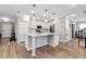 Bright kitchen featuring a white island, shaker cabinets, stainless steel appliances and wood-look flooring at 8346 Abalone Loop, Parrish, FL 34219