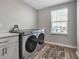 Modern laundry room with front load washer/dryer and a window that provides natural light at 8346 Abalone Loop, Parrish, FL 34219