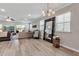 Bright living room with wood-look flooring, chandelier, and an oversized mirror at 8346 Abalone Loop, Parrish, FL 34219
