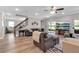 Cozy living room featuring wood floors, a staircase, a plush sofa, and a view of the backyard at 8346 Abalone Loop, Parrish, FL 34219
