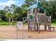 Community playground with wooden play structure, slide, and swings surrounded by lush greenery at 8346 Abalone Loop, Parrish, FL 34219