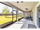 Relaxing screened porch with ceiling fans and a view of the green backyard at 8346 Abalone Loop, Parrish, FL 34219