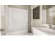 Well-lit bathroom featuring a combination tub and shower, white tile, and modern fixtures at 8505 Snowfall St, Sarasota, FL 34241