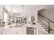 Open-concept kitchen with stainless appliances, white cabinets, and an adjacent dining area with staircase at 8505 Snowfall St, Sarasota, FL 34241