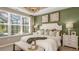 Elegant main bedroom with a decorative lighting fixture, a wall of windows and a luxurious ensuite bathroom at 8505 Snowfall St, Sarasota, FL 34241