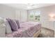 Inviting bedroom with a large window and a comfortable bed adorned with decorative patterned bedding at 9095 Rally Spring Loop, Wesley Chapel, FL 33545